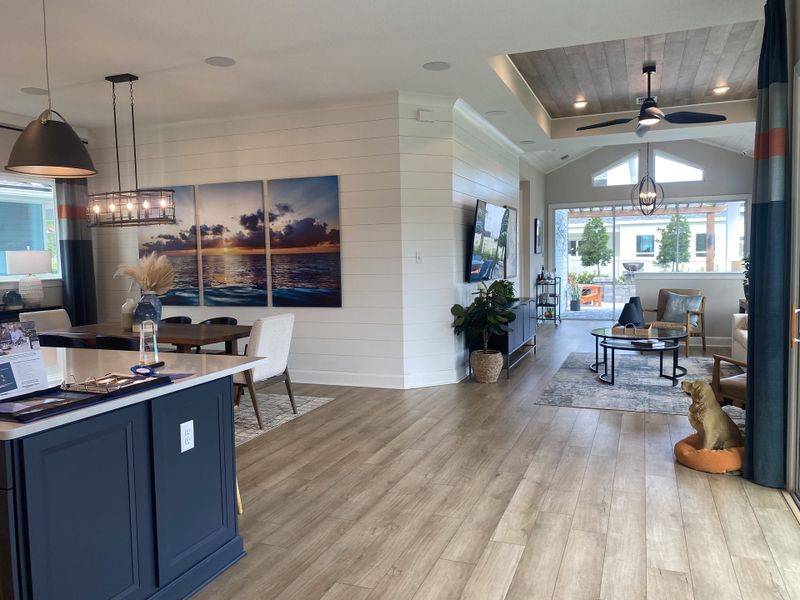 A modern open living space with wood floors, elegant lighting, and vibrant artwork, creating a cozy yet stylish atmosphere.