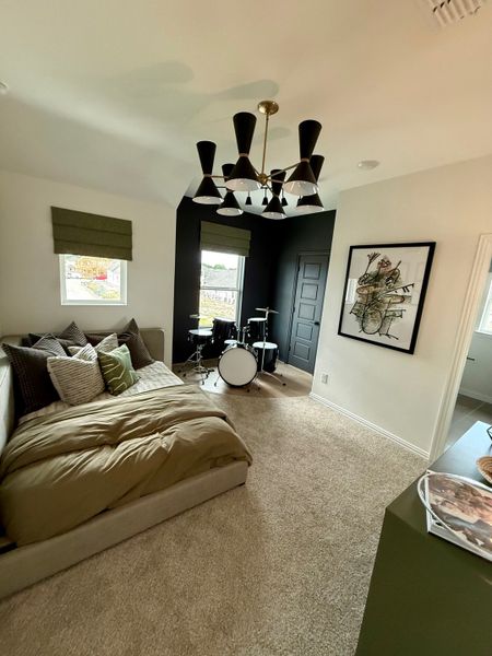 A cozy room with a stylish bed, black accent wall, modern chandelier, and a drum set, perfect for relaxation and music. A cozy room with a stylish bed, black accent wall, modern chandelier, and a drum set, perfect for relaxation and music.