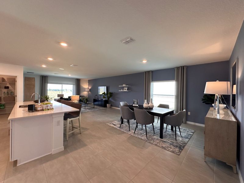 An open-concept living space with sleek gray walls, modern furniture, and a kitchen island with seating.