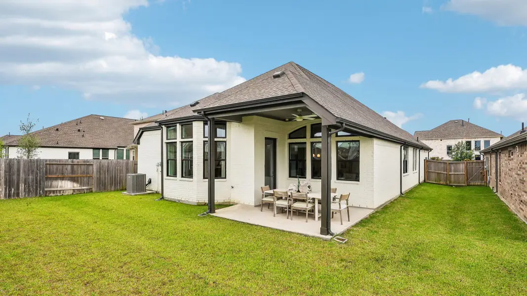 Spacious Sunterra residence features expansive windows and a refined, covered patio amid lush greenery. Spacious Sunterra residence features expansive windows and a refined, covered patio amid lush greenery.