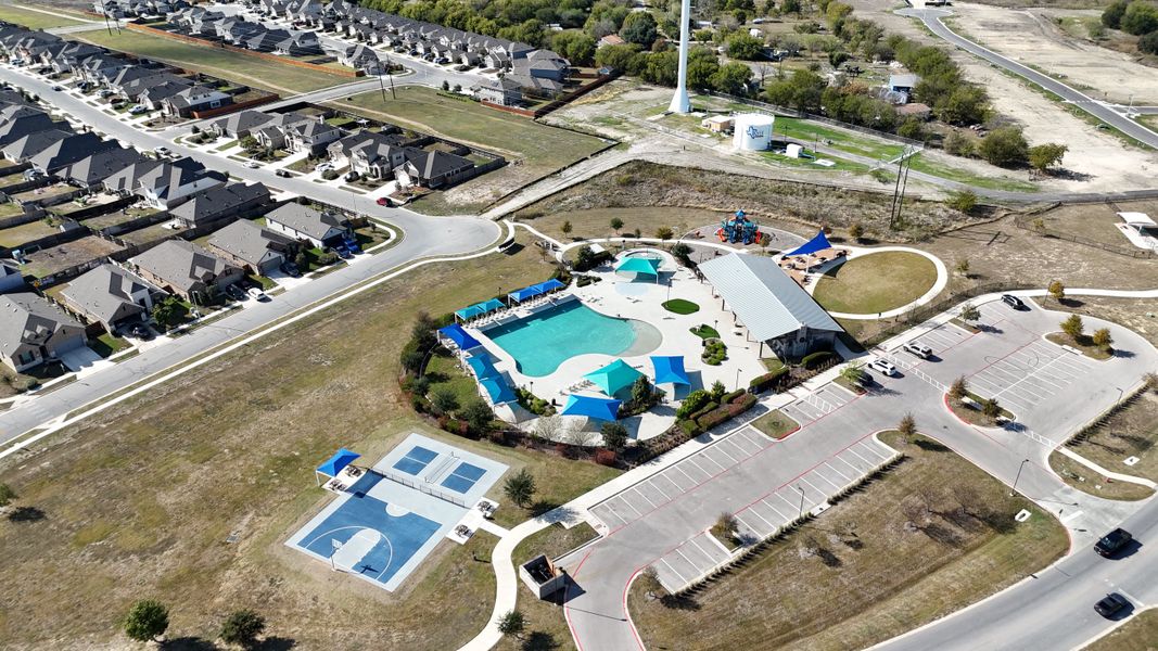 Aerial view of a vibrant community with pools and courts in Crosswinds by Milestone Community Builders (Kyle, TX). Aerial view of a vibrant community with pools and courts in Crosswinds by Milestone Community Builders (Kyle, TX).