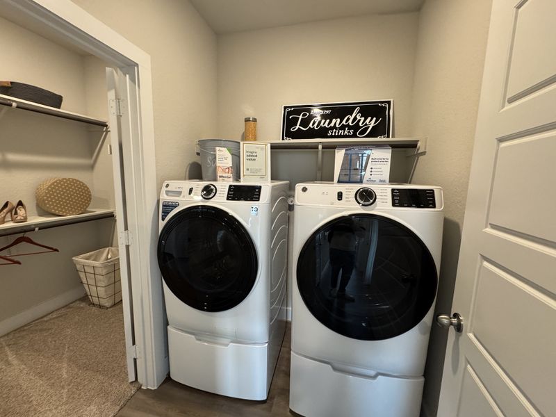 A practical laundry room with modern appliances, closet space, and humorous decor for a convenient and organized touch. A practical laundry room with modern appliances, closet space, and humorous decor for a convenient and organized touch.