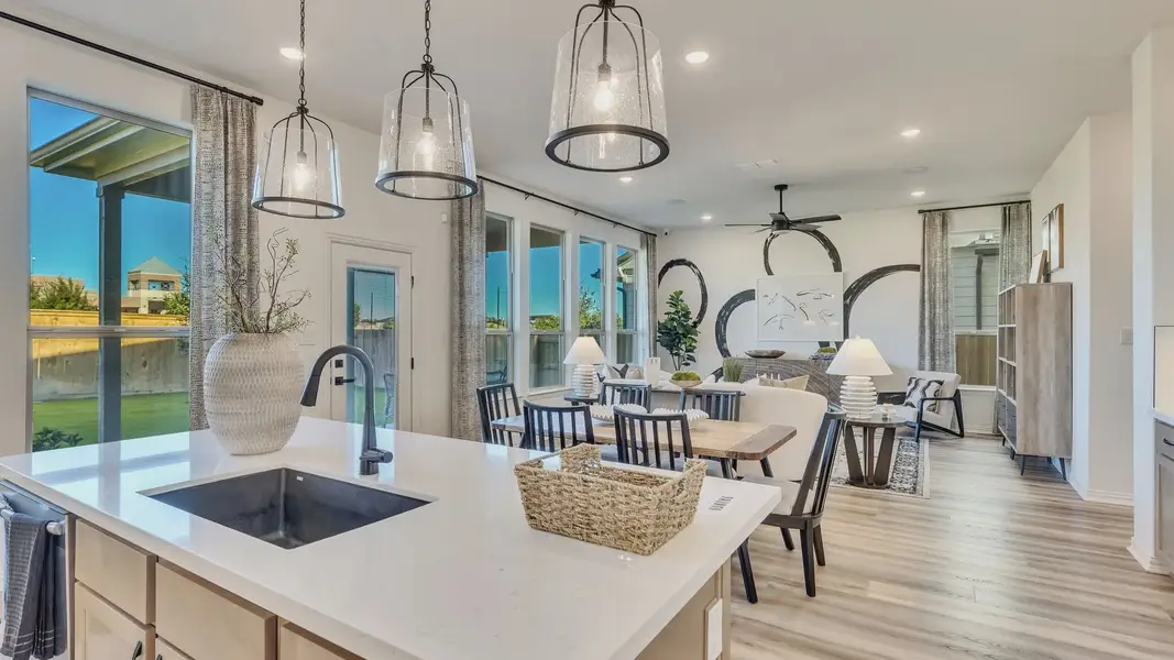 Open-concept space boasts quartz countertops, designer lighting, and expansive windows in Briarwood community.