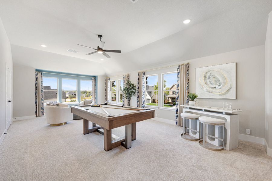 Game room with pool table, vaulted ceiling, ceiling fan, and large windows with natural light