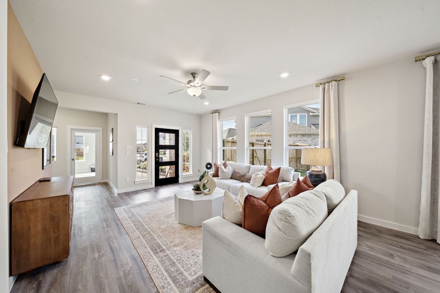 A living room with a large white couch and a large window.