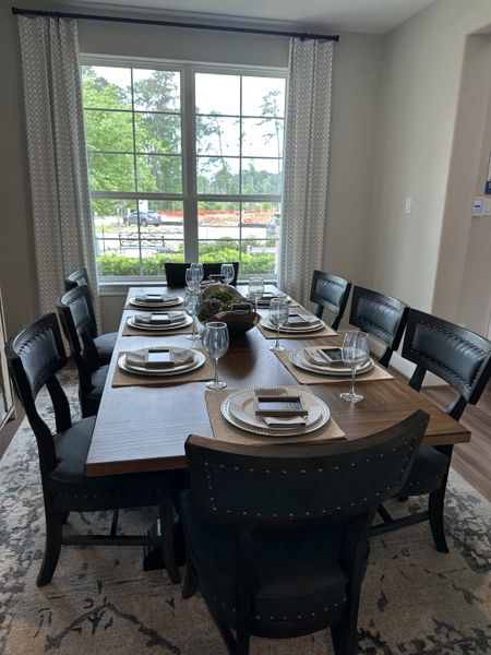 Elegant dining room featuring a wooden table, dark cushioned chairs, and large window, creating a sophisticated atmosphere. Elegant dining room featuring a wooden table, dark cushioned chairs, and large window, creating a sophisticated atmosphere.