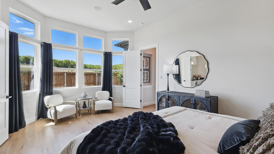 Expansive windows illuminate sleek hardwood floors and elegant decor in Green Oaks Preserve's serene bedroom. Expansive windows illuminate sleek hardwood floors and elegant decor in Green Oaks Preserve's serene bedroom.