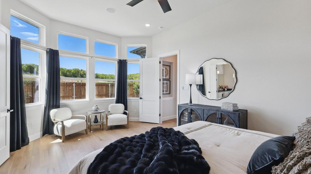 Bright primary suite featuring large windows, a sitting area, and elegant designer finishes. Bright primary suite featuring large windows, a sitting area, and elegant designer finishes.