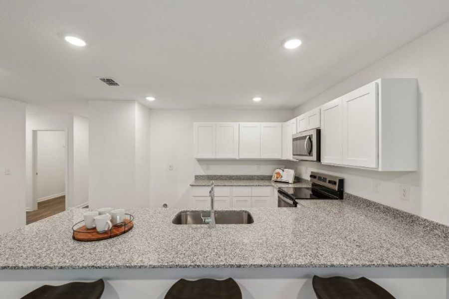 A kitchen with white cabinets.