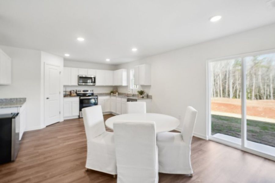 A large kitchen with a large dining table and white chairs. A large kitchen with a large dining table and white chairs.