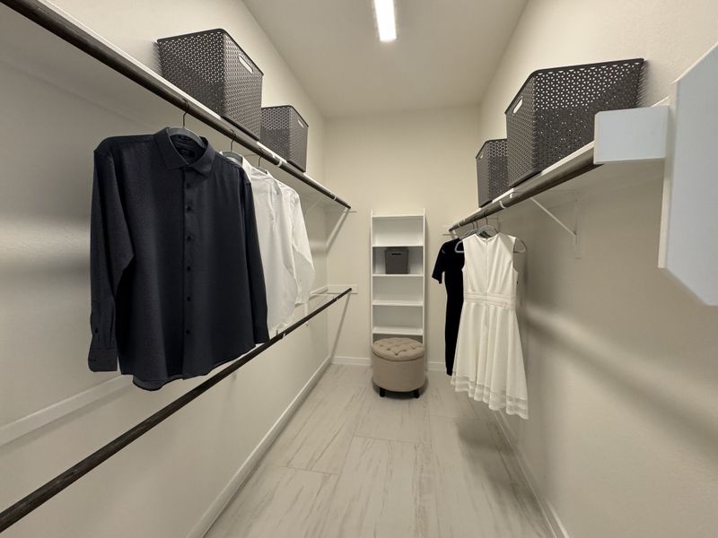 A spacious walk-in closet with built-in shelving, hanging space, and storage baskets, offering a well-organized and stylish dressing area.