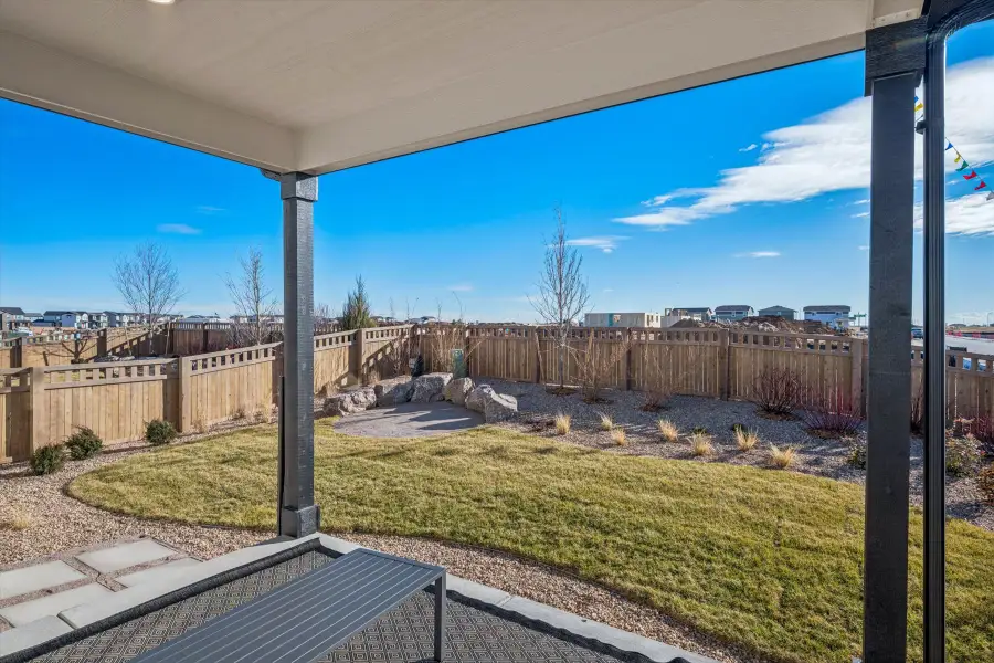 A fenced in yard with a stone wall and a stone wall.