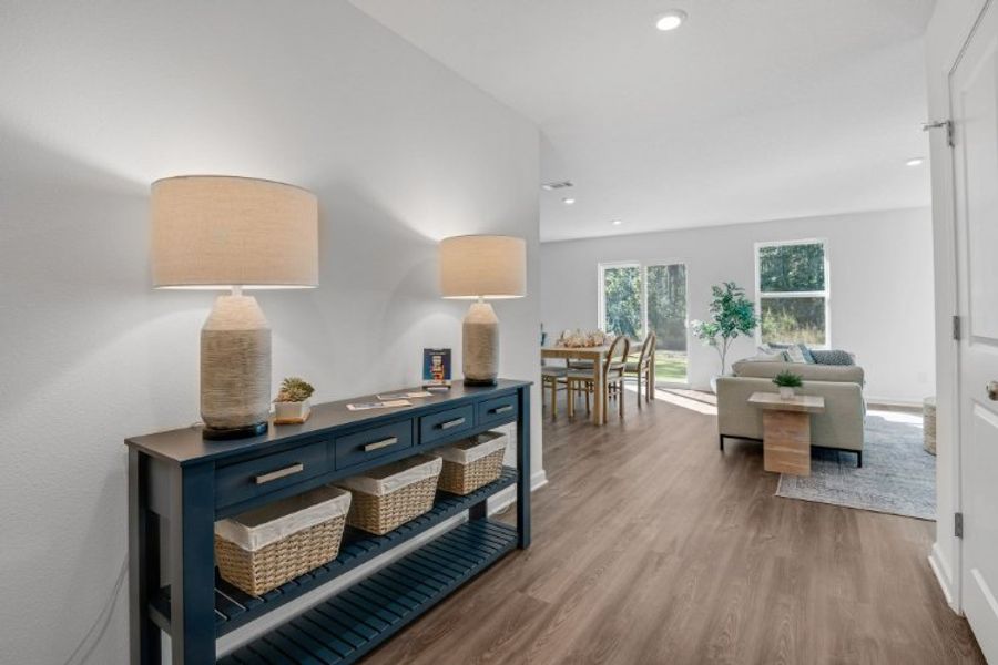 A room with a wood floor and a wood floor with a table and chairs and a lamp.