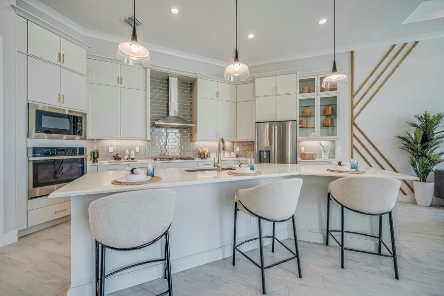 Kitchen | Sage Model:Island Kitchen with white cabinets, quarts and gold accents. grey tile backsplash
