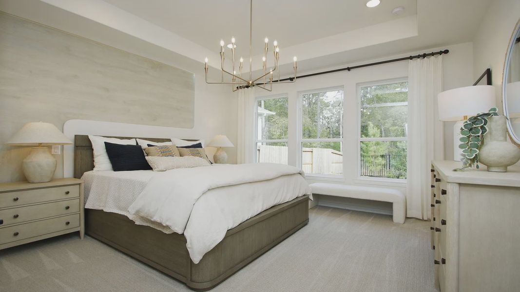 Experience refined elegance with a grand chandelier and expansive windows in The Woodlands Hills.