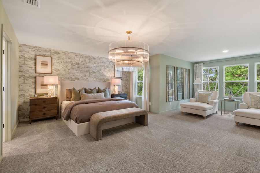 A large bedroom with a bed and a chandelier.