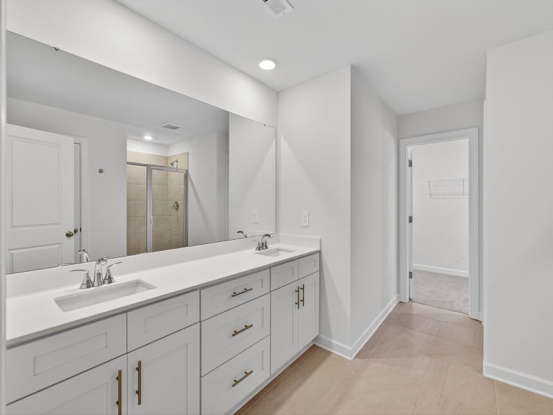 The primary bathroom boasts a dual-sink vanity and modern walk-in shower.