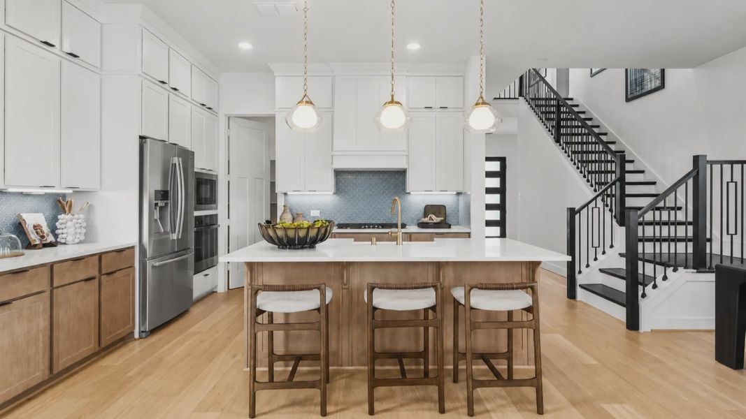 Modern kitchen in Bridgeland Central with soft wood tones and crisp white cabinets and counters.