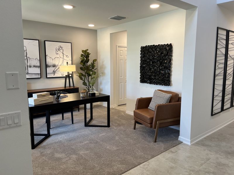 A modern office space with sleek black furniture, abstract art, and cozy carpet, creating a stylish and functional environment.