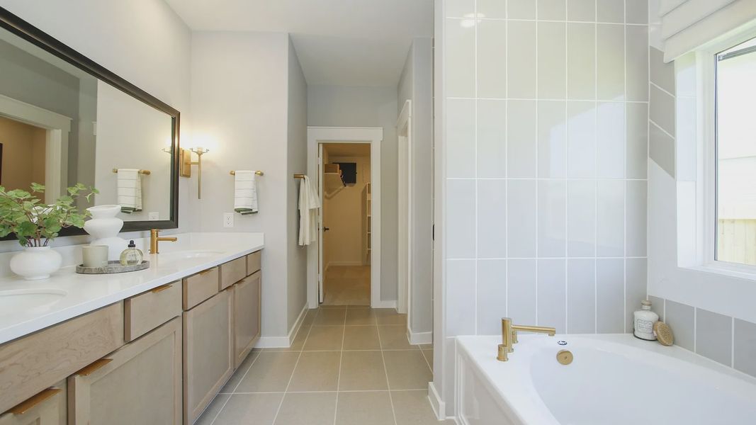 Elegant bathroom in Cielo featuring marble counters, dual sinks, and luxe gold fixtures. Exquisite design.