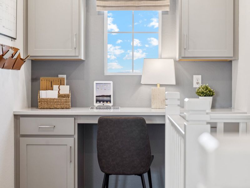 A white kitchen with a black chair.