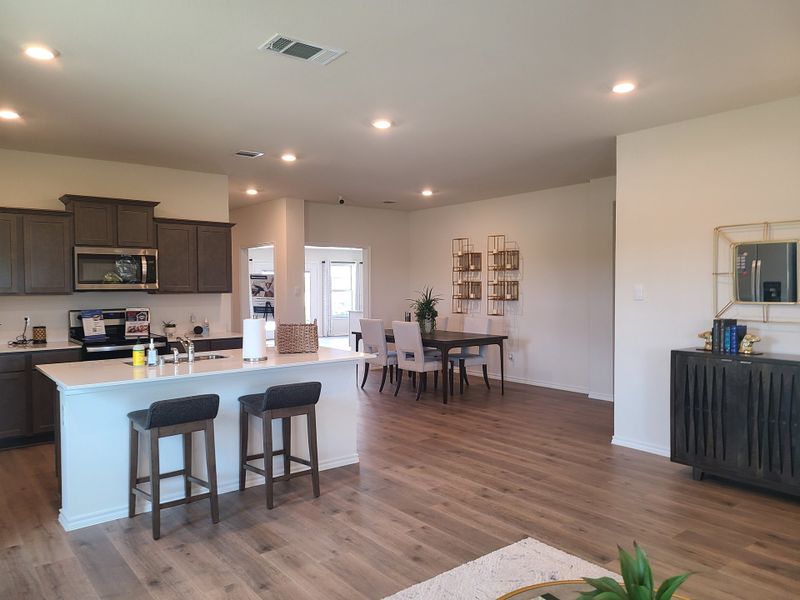 An open-concept kitchen and dining area with a sleek island, modern cabinetry, and elegant decor accents.