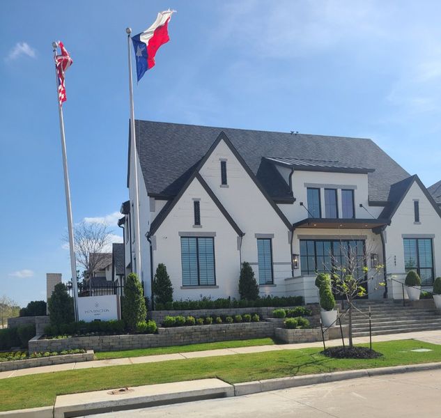 A modern white brick home with manicured landscaping in the Fields community by Huntington Homes (Frisco, TX).