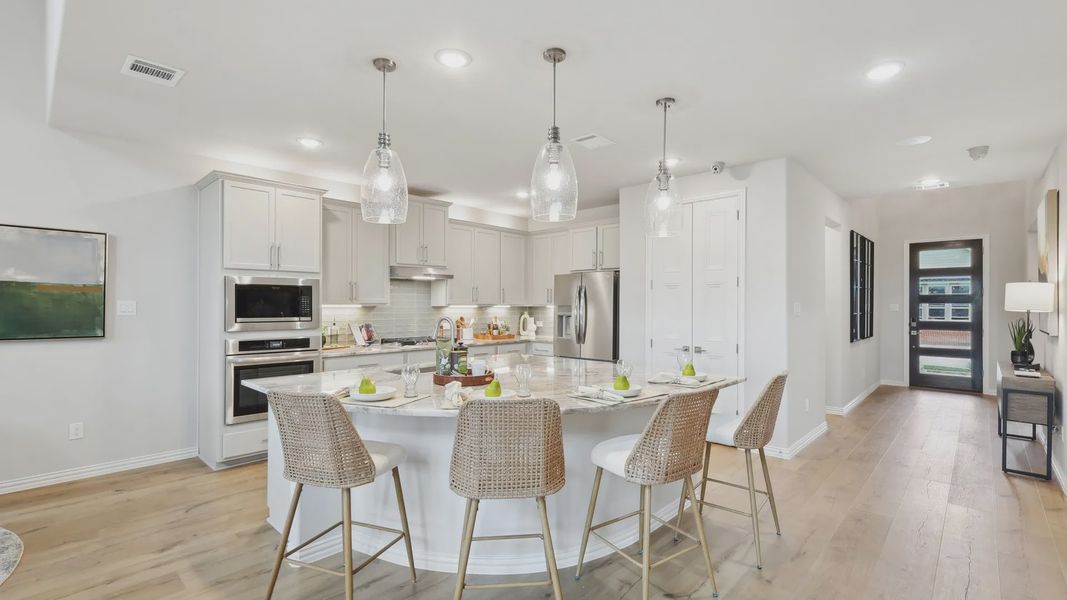 Elegant marble island complements woven barstools in luxurious Wildflower Ranch kitchen. Elegant marble island complements woven barstools in luxurious Wildflower Ranch kitchen.