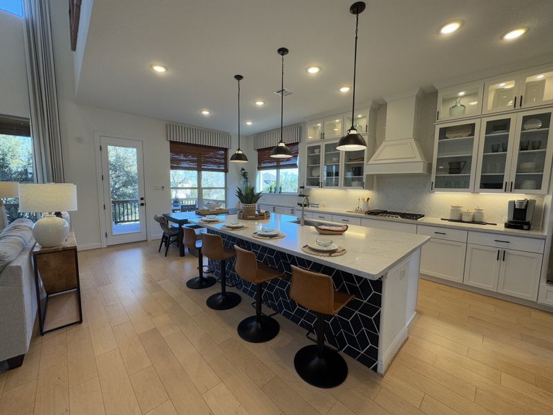 A modern kitchen with an island, sleek lighting, wood floors, and large windows overlooking a scenic view. A modern kitchen with an island, sleek lighting, wood floors, and large windows overlooking a scenic view.