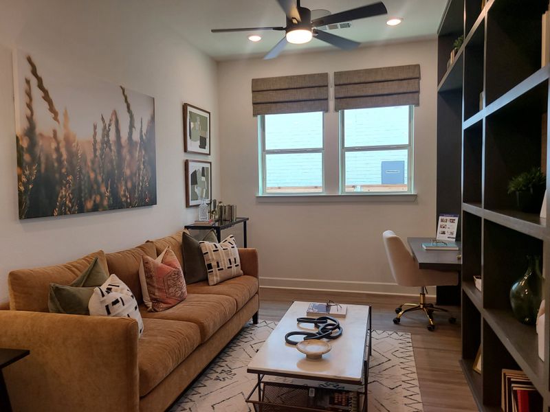 A cozy study with a tan sofa, abstract art, and chic shelving, featuring an elegant corner desk. A cozy study with a tan sofa, abstract art, and chic shelving, featuring an elegant corner desk.