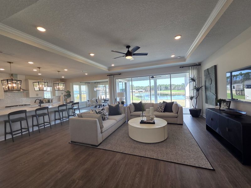 An open-plan living area with cozy seating, modern kitchen, and large windows showcasing serene outdoor views.