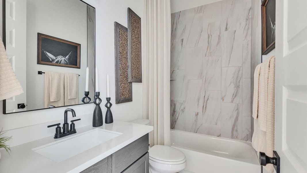 Indulge in opulence with marble tile walls and sleek fixtures in Briarwood, showcasing modern elegance.