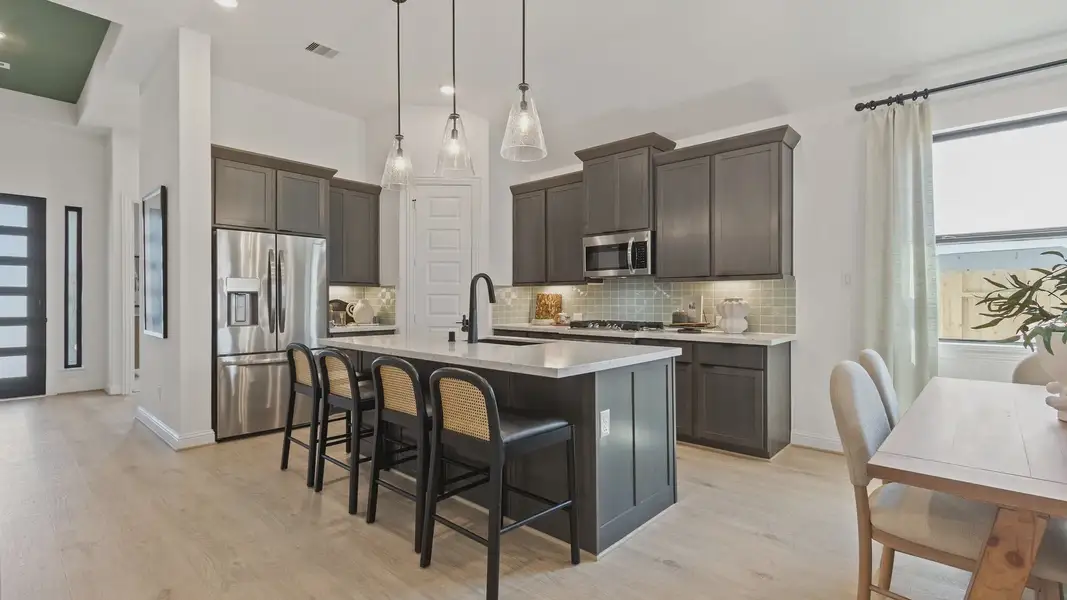 Experience elegance with high-end cabinetry, chic lighting, and a spacious island in Texas's Oakwood Estates. Experience elegance with high-end cabinetry, chic lighting, and a spacious island in Texas's Oakwood Estates.