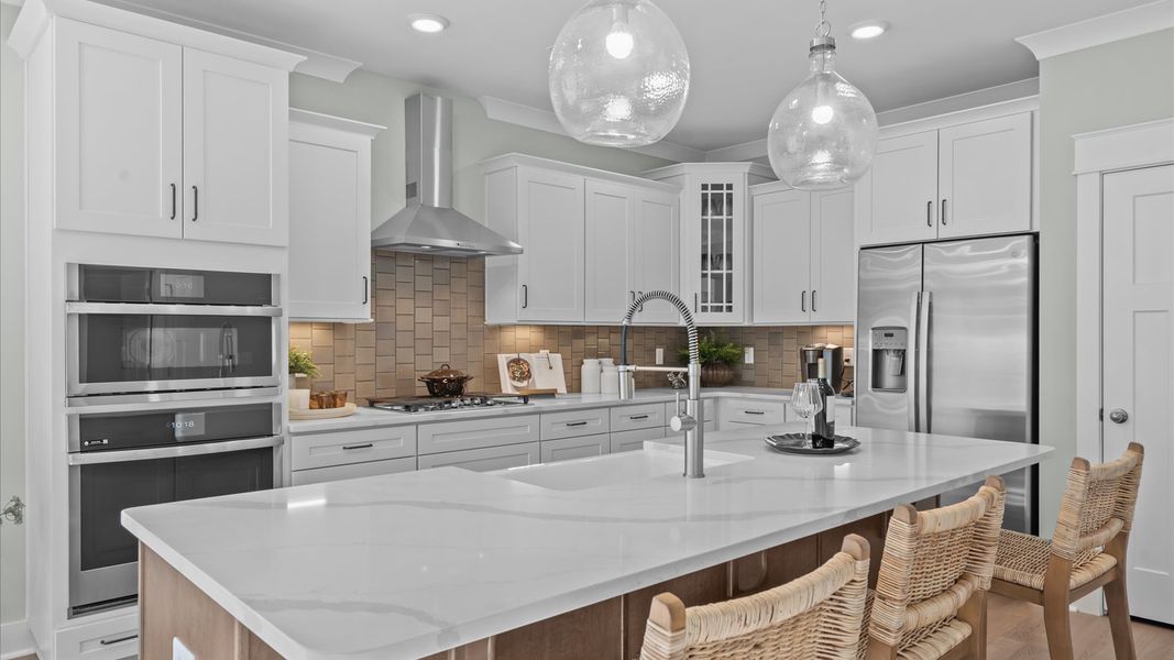 Exceptional kitchen featuring a spacious island, eye-catching pendant lights, and modern finishes by DRB Homes Exceptional kitchen featuring a spacious island, eye-catching pendant lights, and modern finishes by DRB Homes