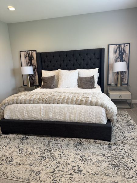 A cozy bedroom featuring a plush tufted headboard, elegant bedding, and sleek nightstands with modern lamps.