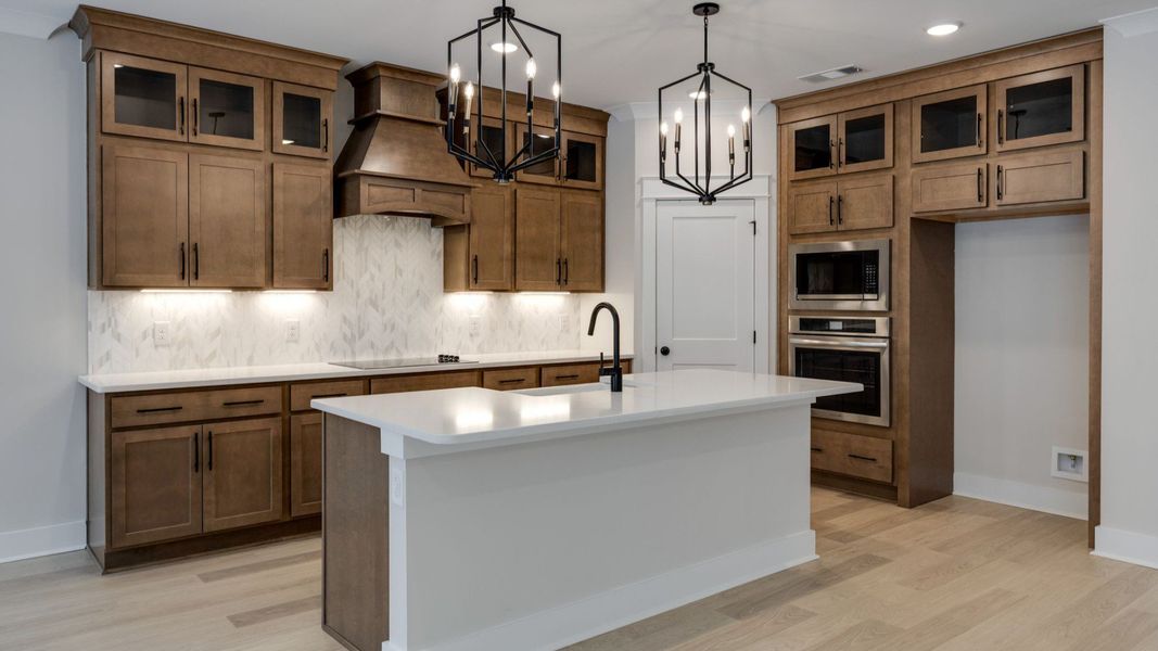 Kitchen with quartz countertops, pendant lighting, and hard surface flooring