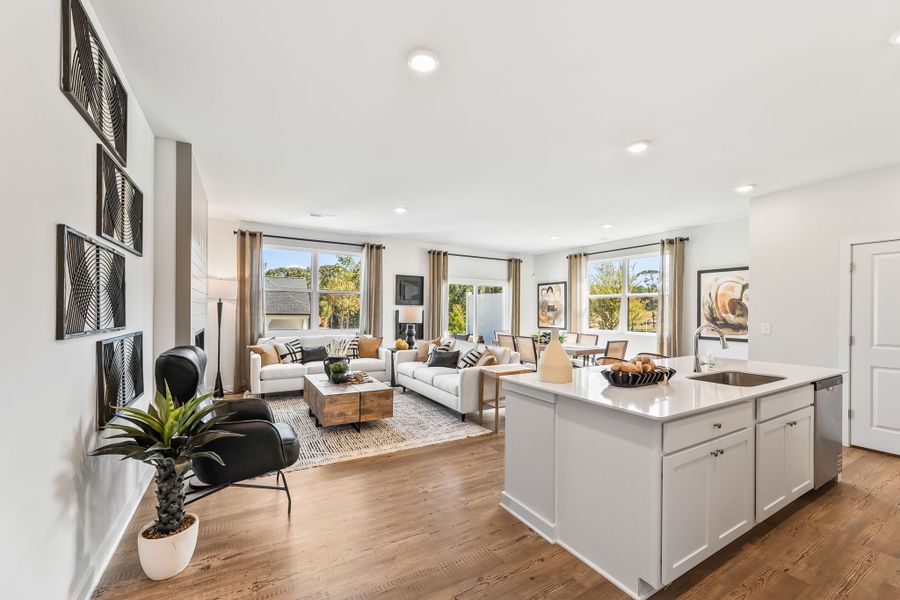 A large living room with a large kitchen and a large window. A large living room with a large kitchen and a large window.