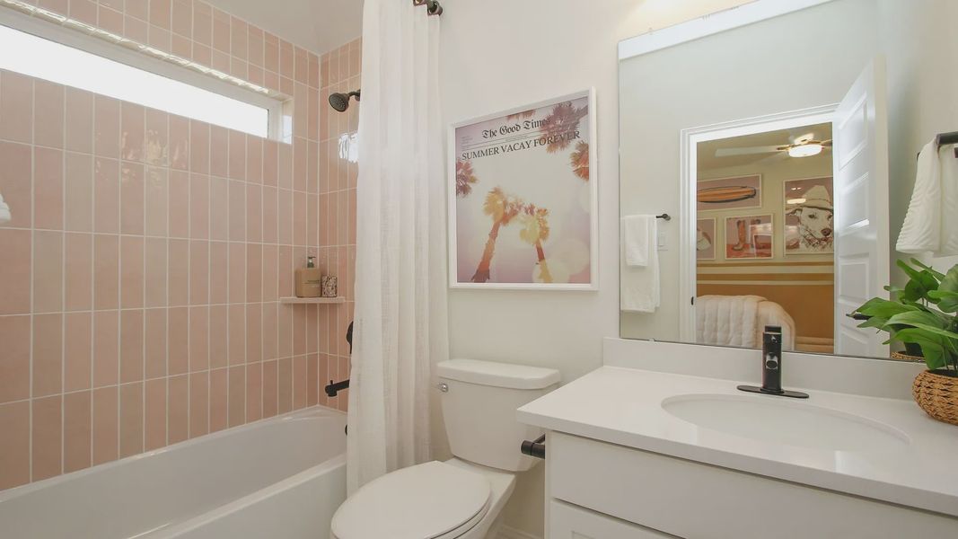 Luxurious bathroom features elegant pink tiles and modern fixtures in The Woodlands Hills.
