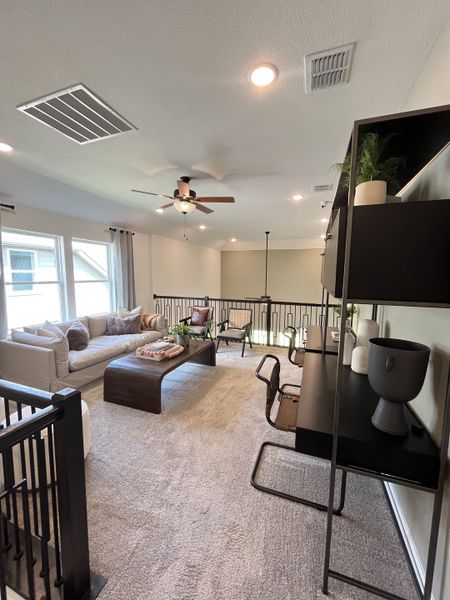 A modern loft with cozy carpeting, sleek furniture, and ample natural light from large windows. A modern loft with cozy carpeting, sleek furniture, and ample natural light from large windows.