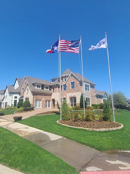 A beautiful brick home with manicured landscaping in Lake Forest by Grand Homes (McKinney, TX).