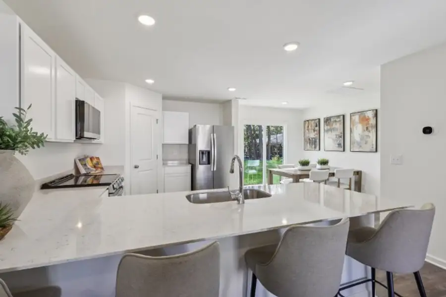 A kitchen with a dining table and chairs.