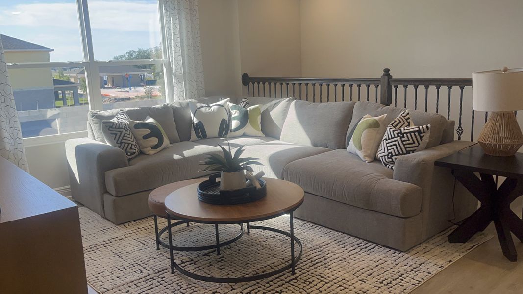 A cozy living room with a sectional sofa, decorative pillows, stylish coffee table, and a large window offering natural light. A cozy living room with a sectional sofa, decorative pillows, stylish coffee table, and a large window offering natural light.