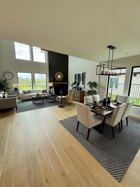 An elegant open living-dining area with hardwood floors, high ceilings, and abundant natural light.