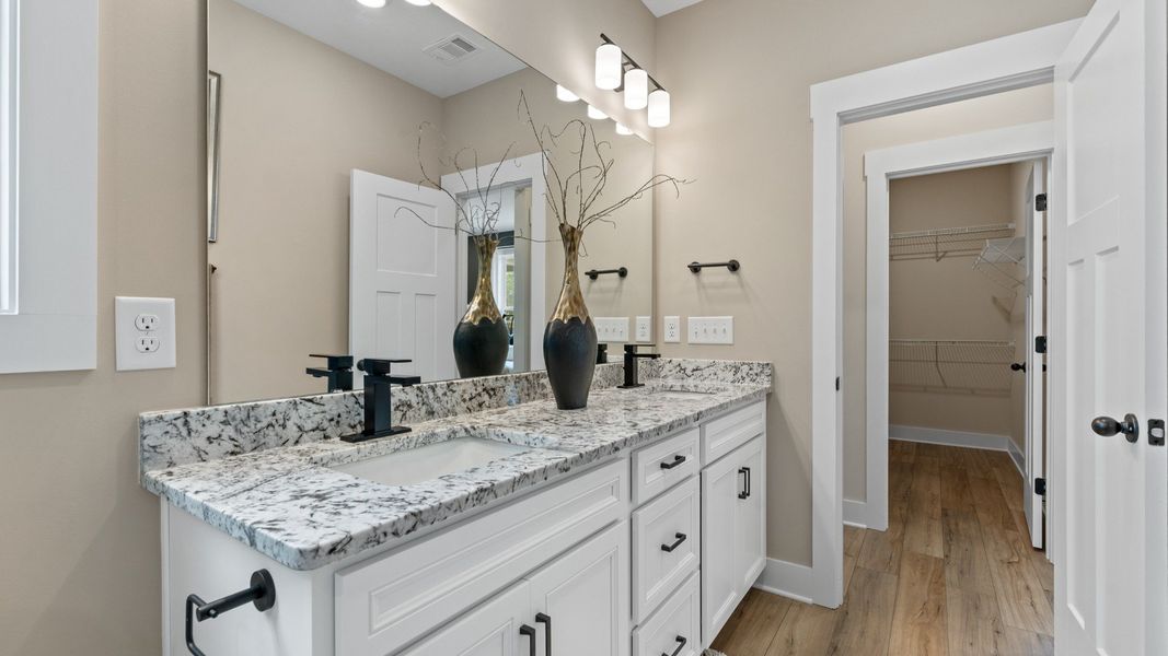 First-rate primary bathroom offering an elegant walk-in shower and dual sinks with superior style