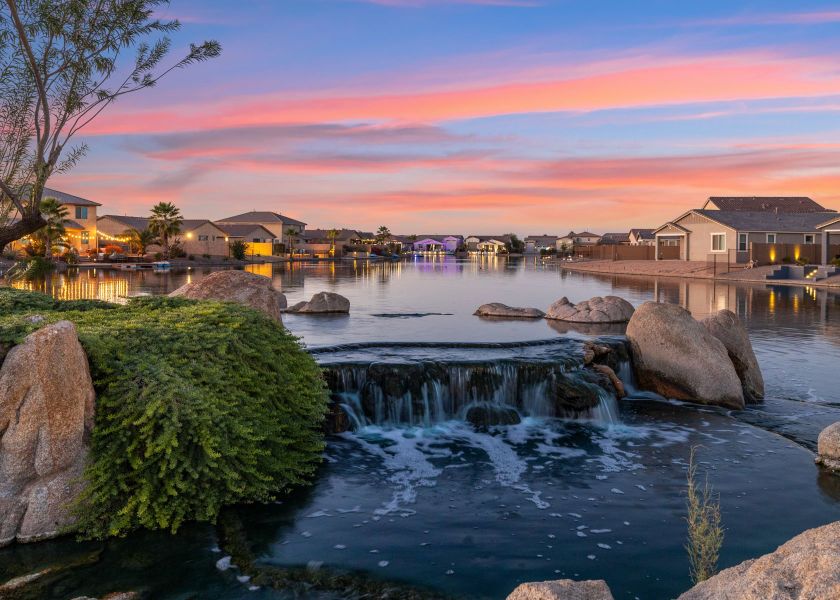 A body of water with rocks and buildings in the background.