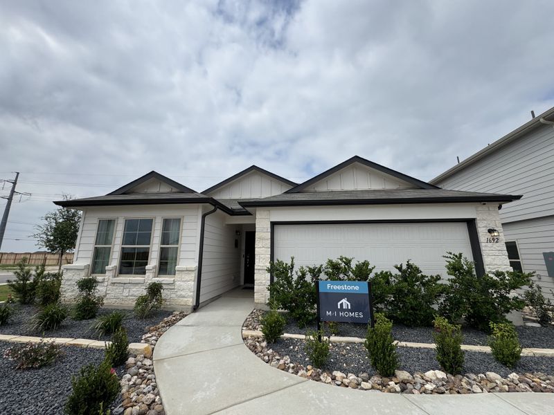 A charming modern home with a sleek driveway and landscaped garden in Clear Spring Meadows by M/I Homes (New Braunfels, TX).