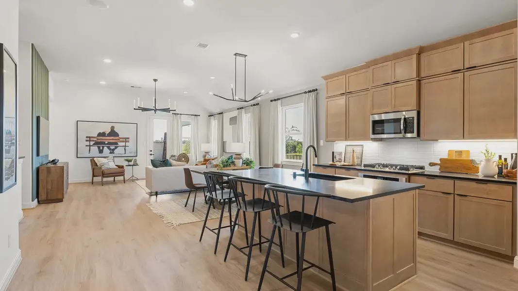 Spacious open-plan living area with elegant wooden cabinets, sleek modern fixtures in Southern Pointe, Texas. [111]