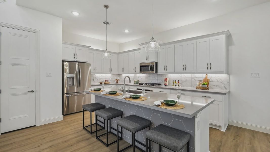 Exquisite kitchen with marble backsplash, sleek island, and premium cabinetry in Solterra, Texas.