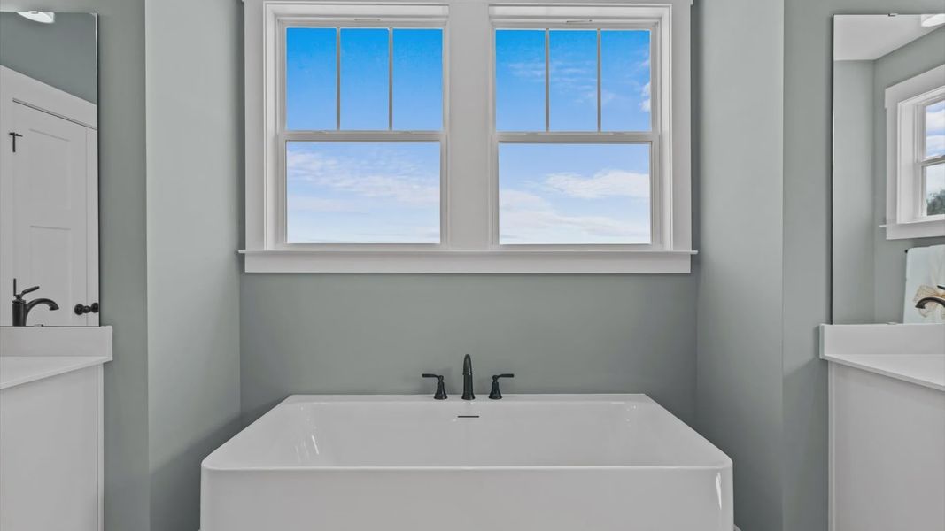 Primary bathroom with spa like bath tub and separate vanities at Pinebrook by DRB Homes in Woodruff, SC Primary bathroom with spa like bath tub and separate vanities at Pinebrook by DRB Homes in Woodruff, SC