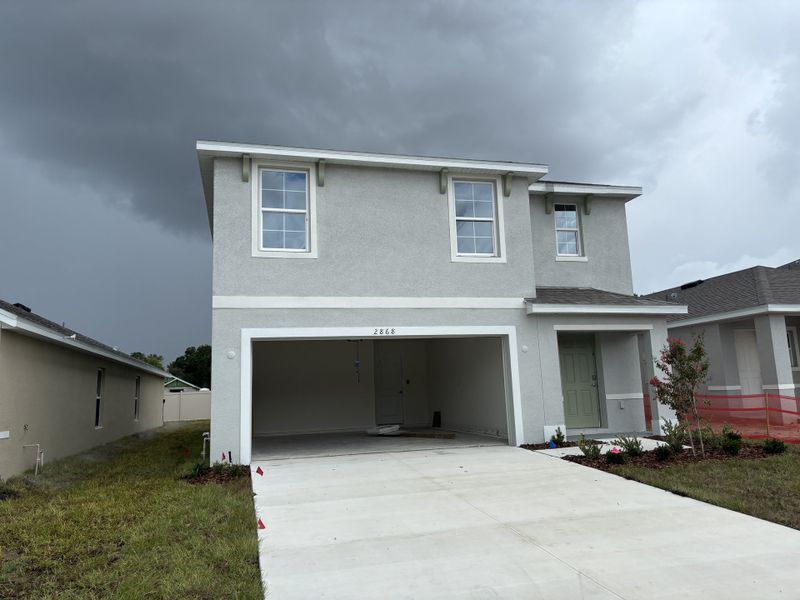Elegant gray two-story home with a spacious garage in Emerson Pointe by D.R. Horton (Ocala, FL).